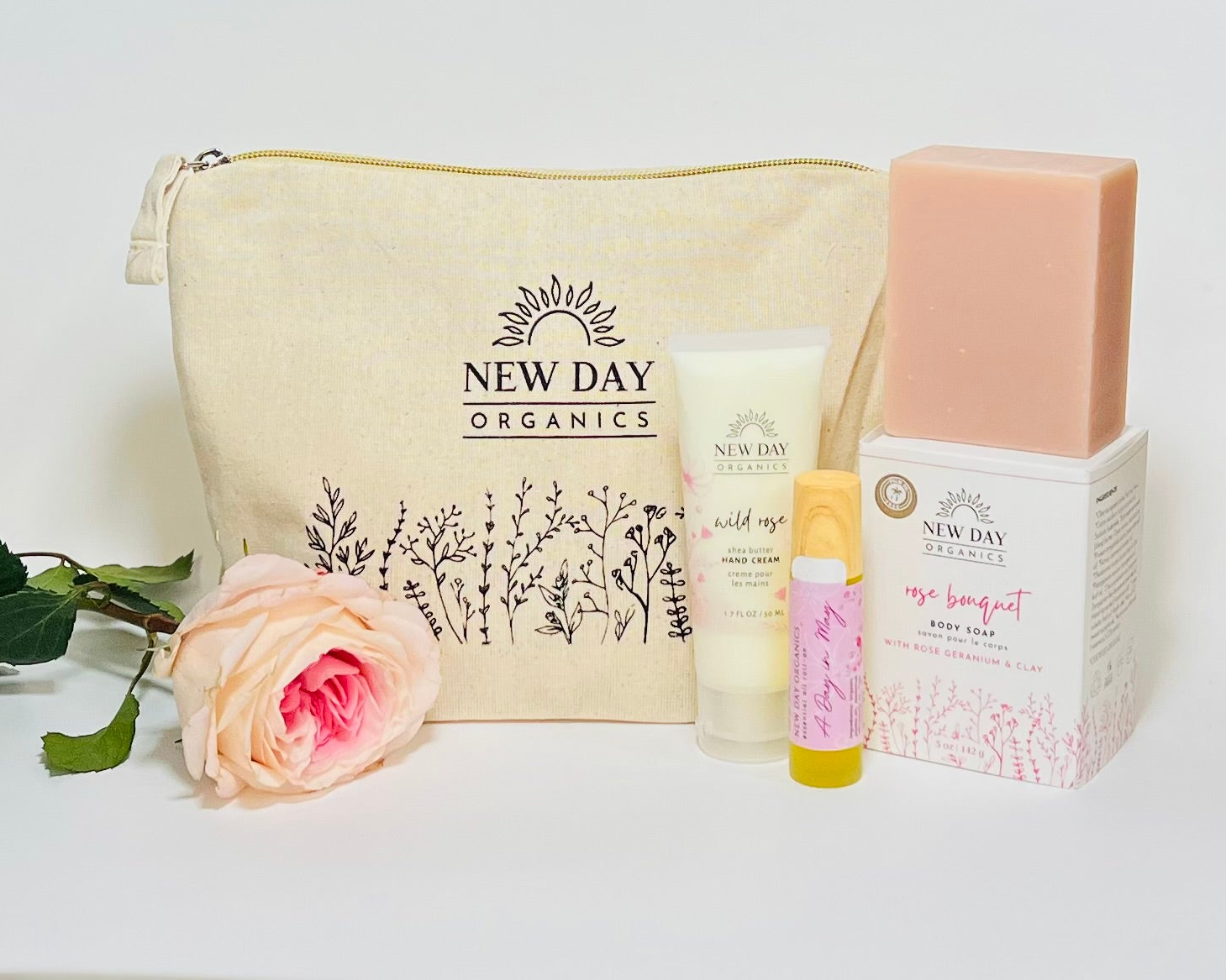 New Day Organics skincare products including a pouch, bottle, and bar of soap on a white background.