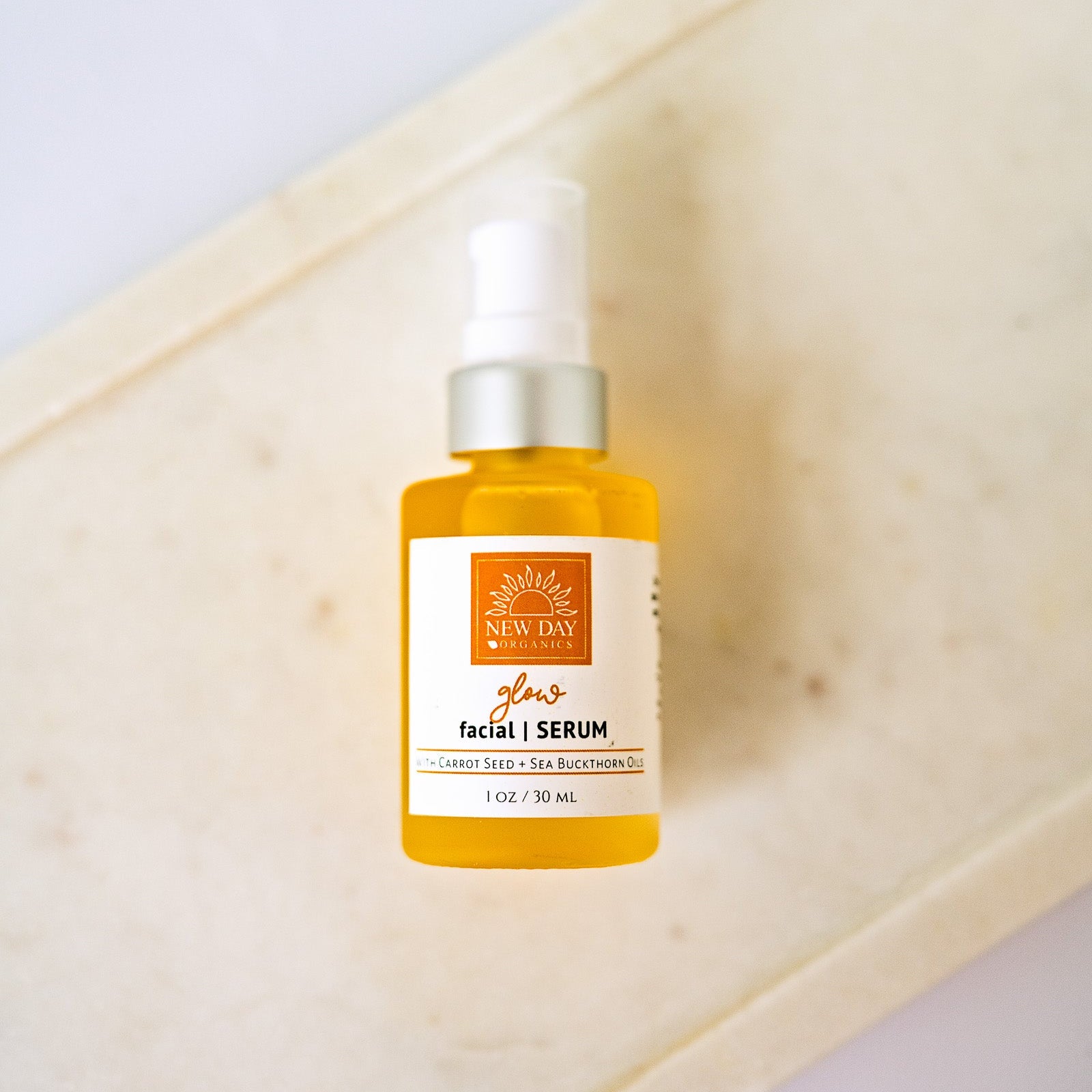 Facial serum bottle on a wooden surface with a white background