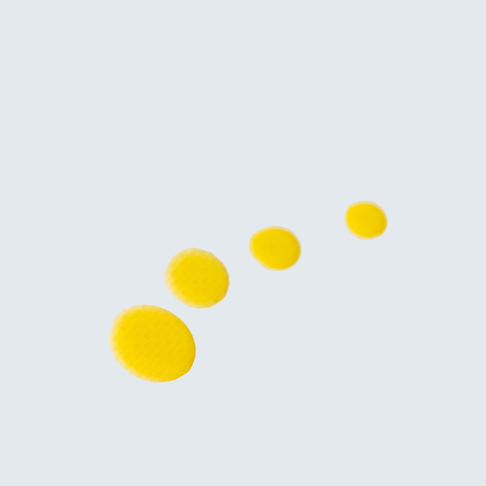 Four yellow dots of varying sizes on a light gray background