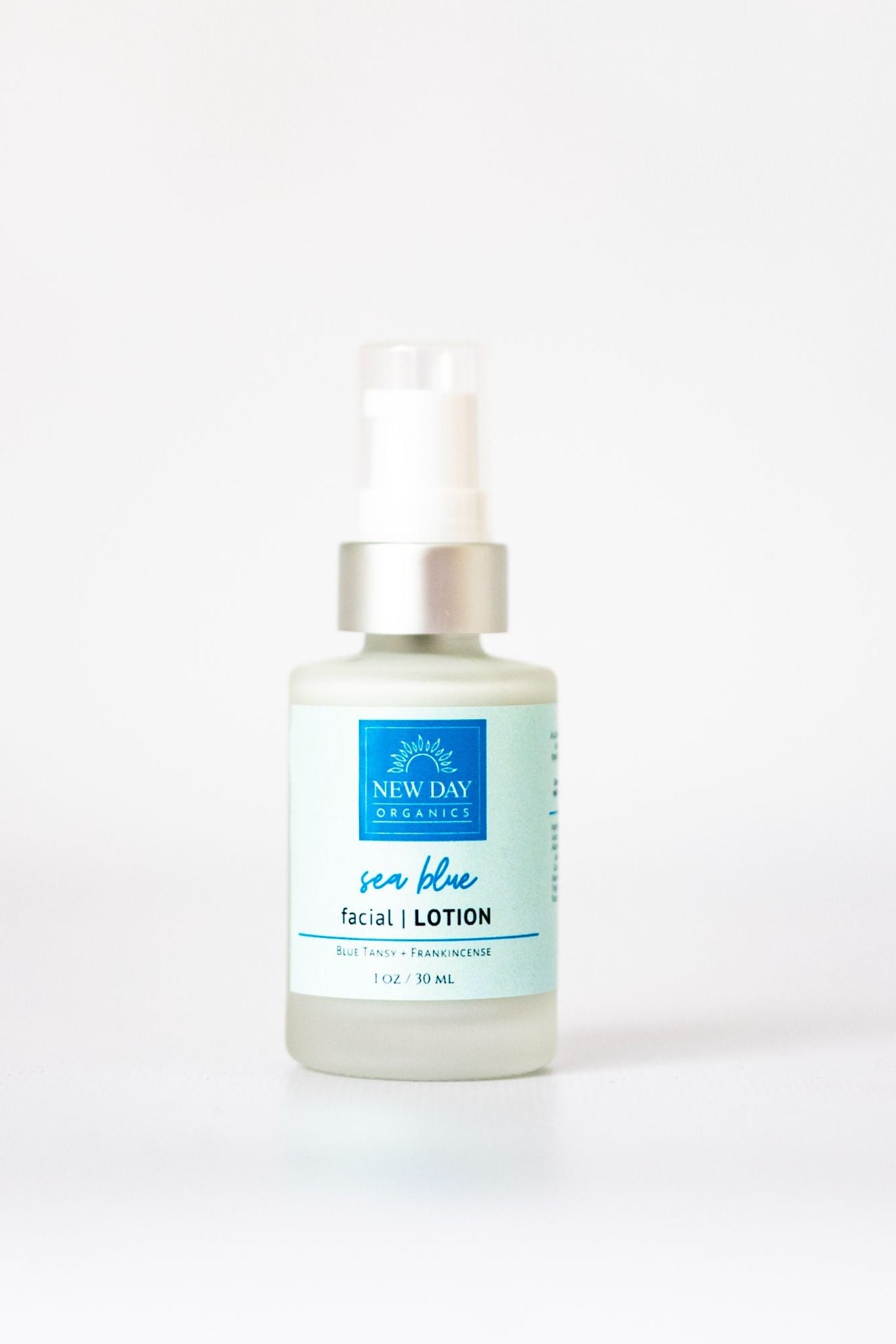 Bottle of New Day Organics Sea Blue facial lotion on a white background