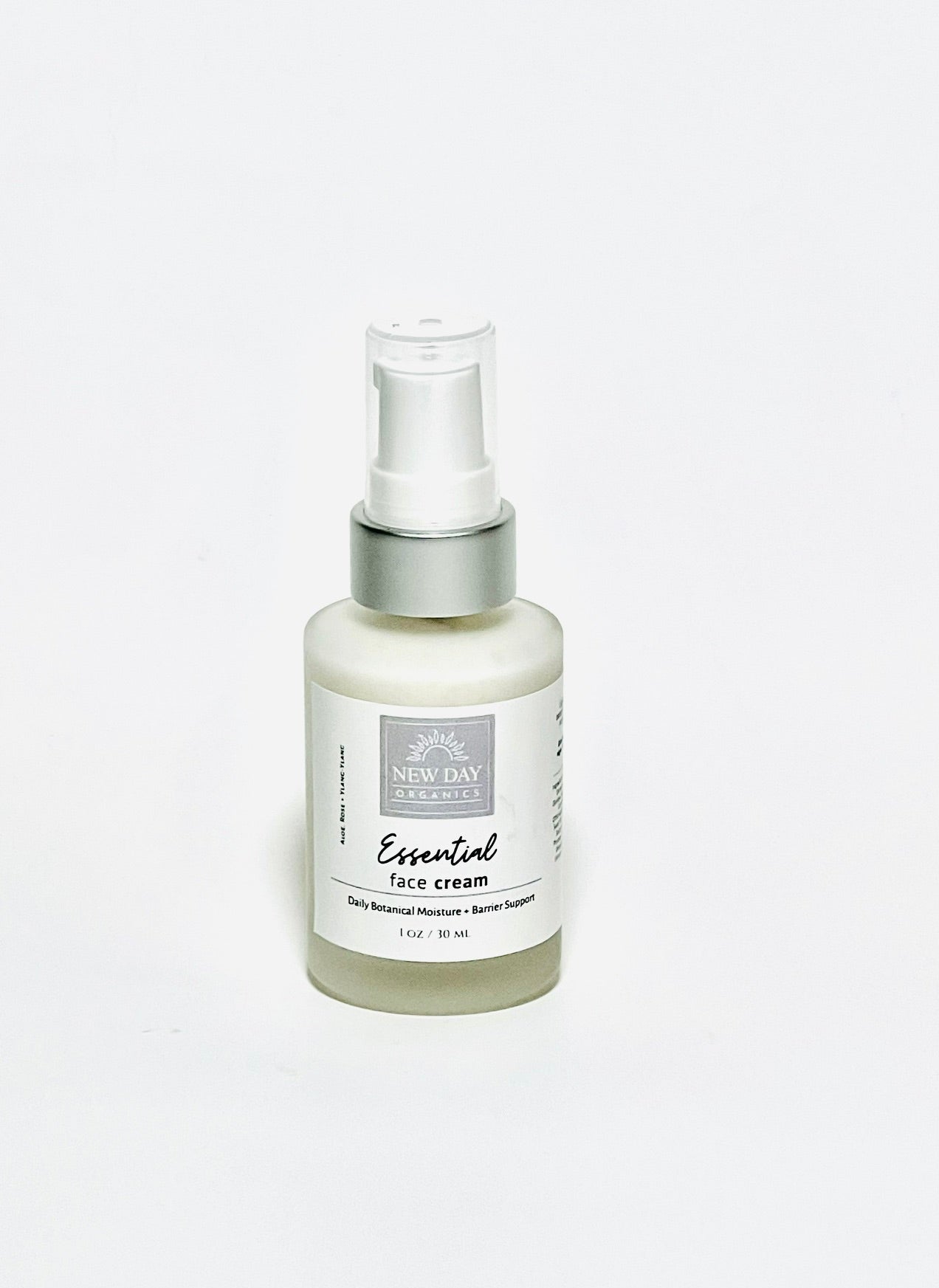 New Day Essentials Essential Face Cream in a frosted glass spray bottle with a white pump and silver collar, set against a plain white background.