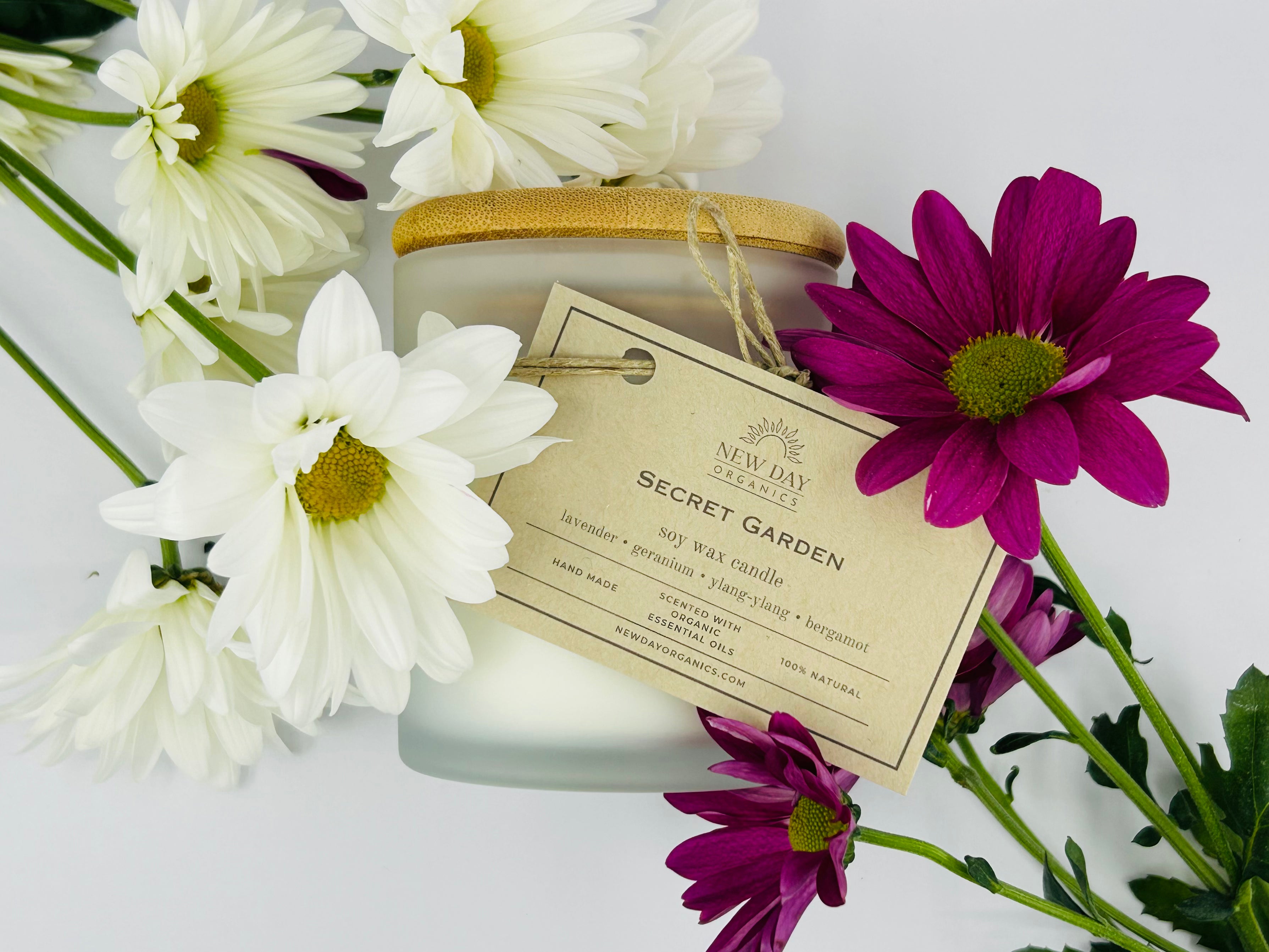Candle labeled 'Secret Garden' with flowers on a white background