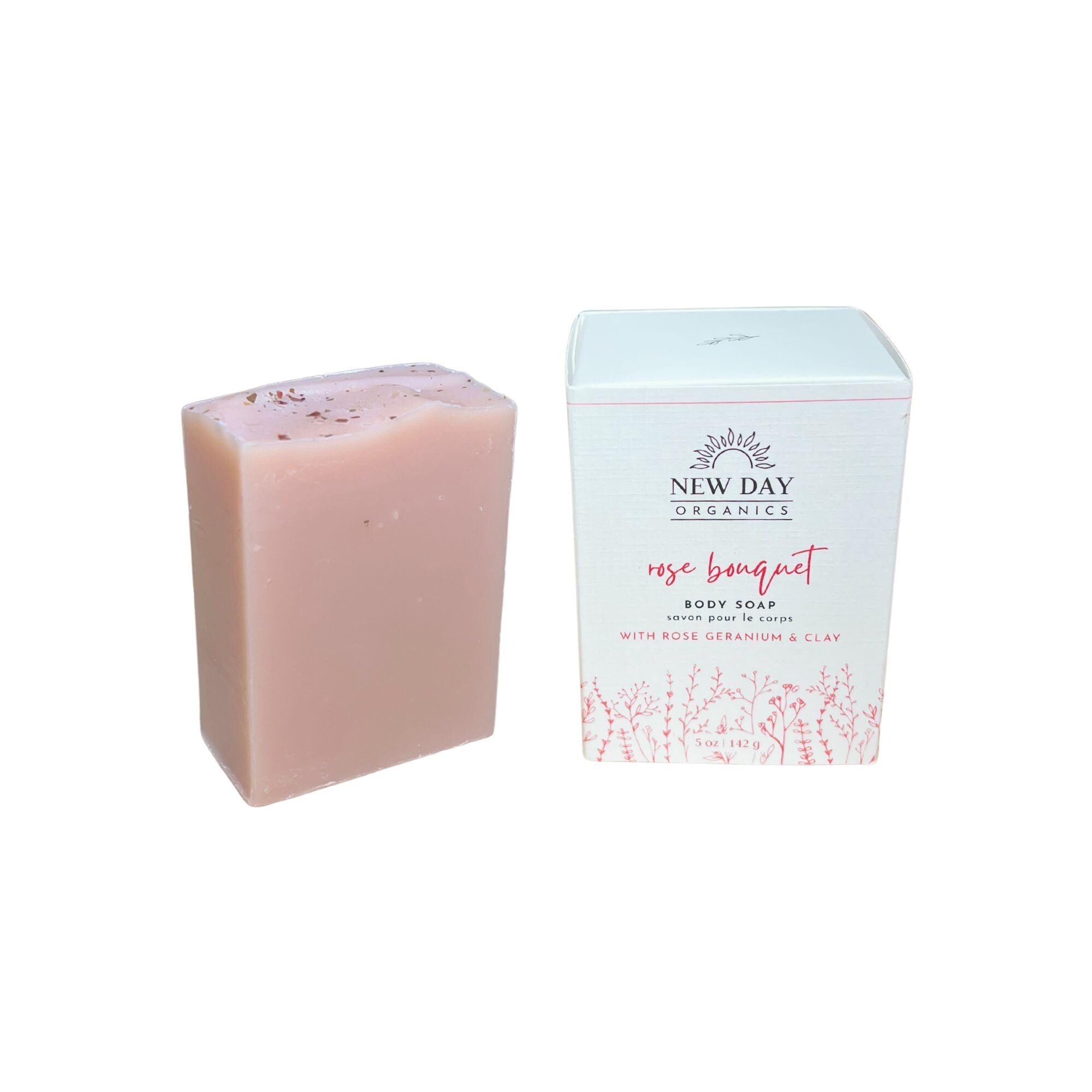 Pink soap bar next to its packaging on a white background