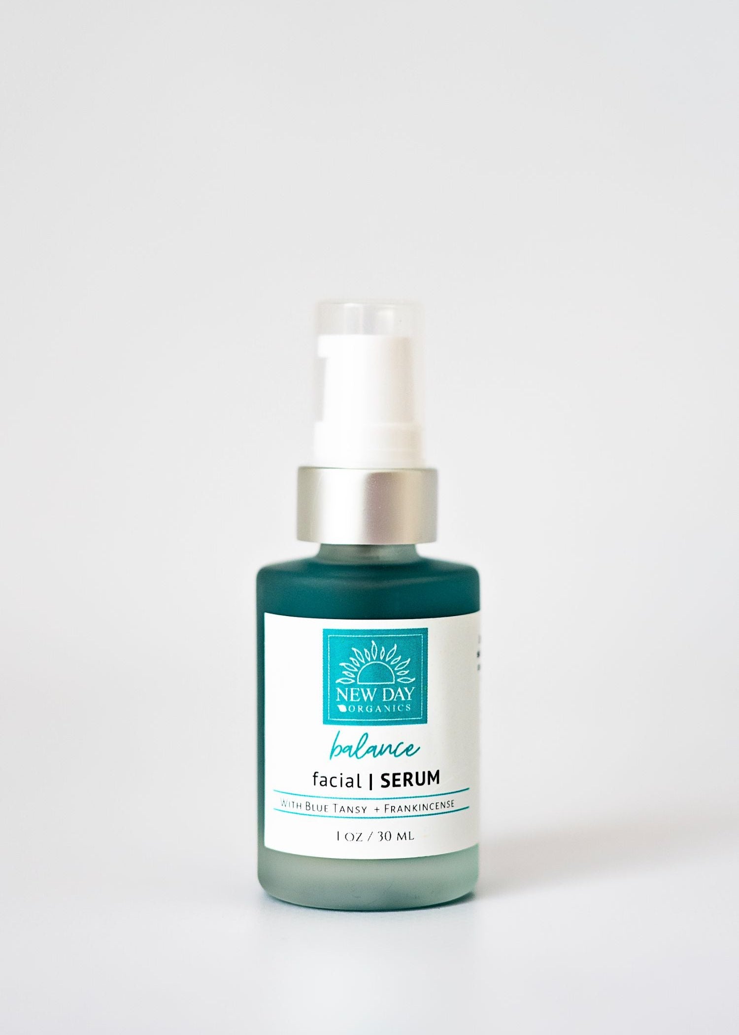 Facial serum bottle with a white label on a light gray background