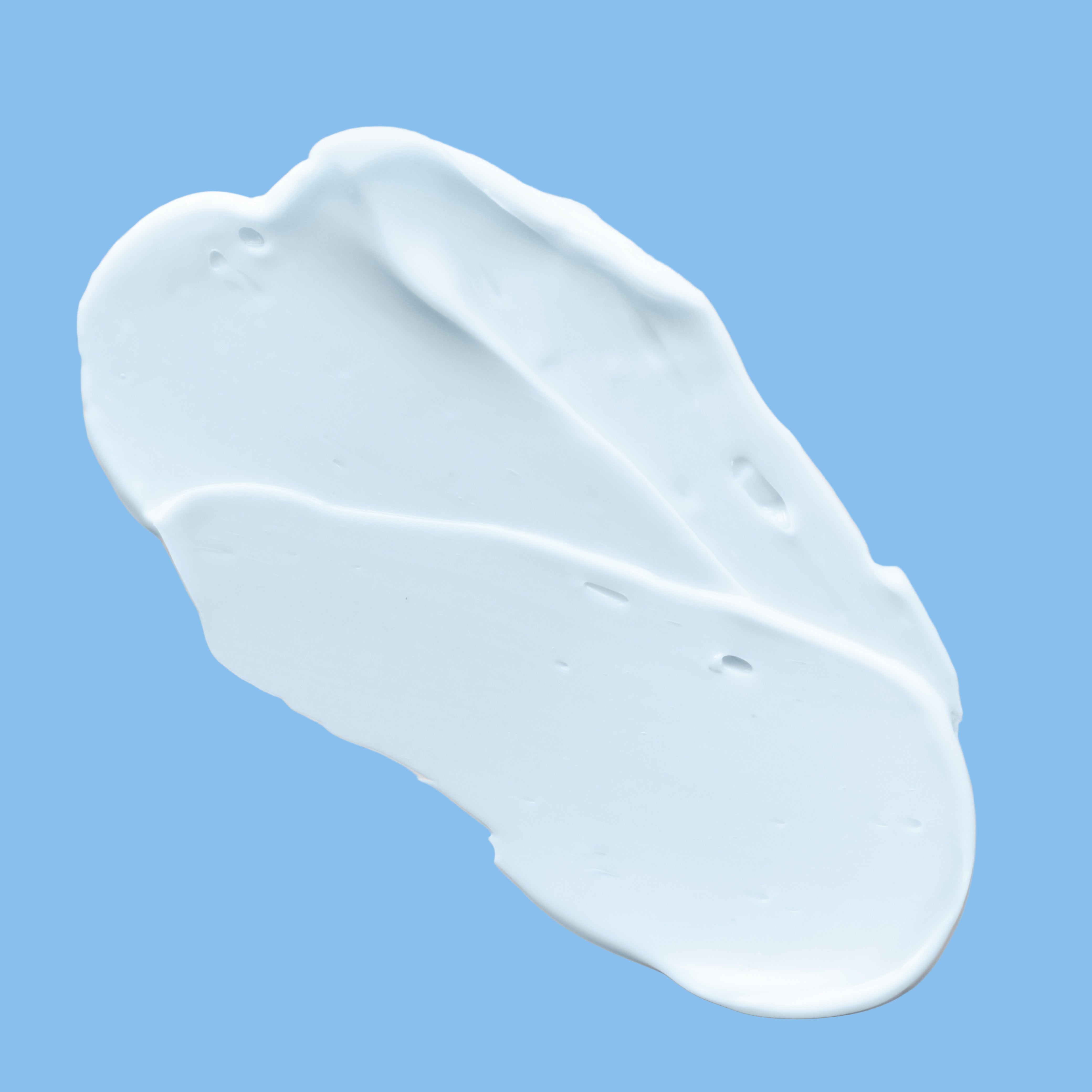 Light blue lotion swatch on a blue background